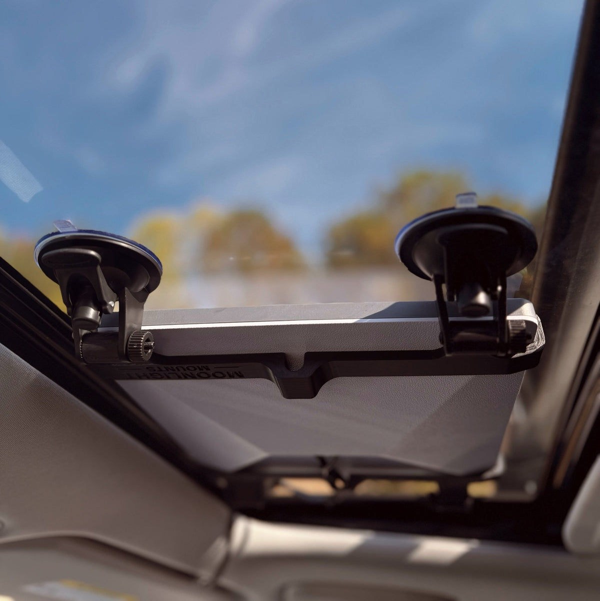 Close-up of the Starlink Mini suction cup mount bracket, two locking suction cups gripping the sunroof glass from inside