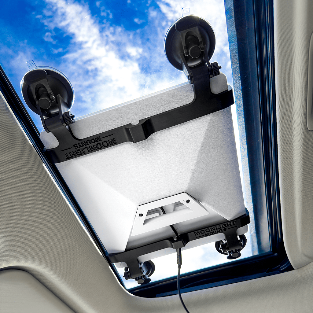 Starlink Mini suction cup mount seen from inside the cabin, four locking suction cups holding the dish against the sunroof glass