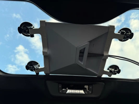 Starlink Mini suction cup mount on a panoramic sunroof seen from inside the car, gray brackets and four suction cups