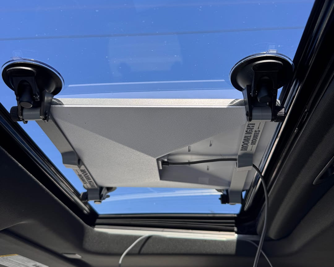 Starlink Mini suction cup mount attached to the inside of a vehicle sunroof, seen from the cabin